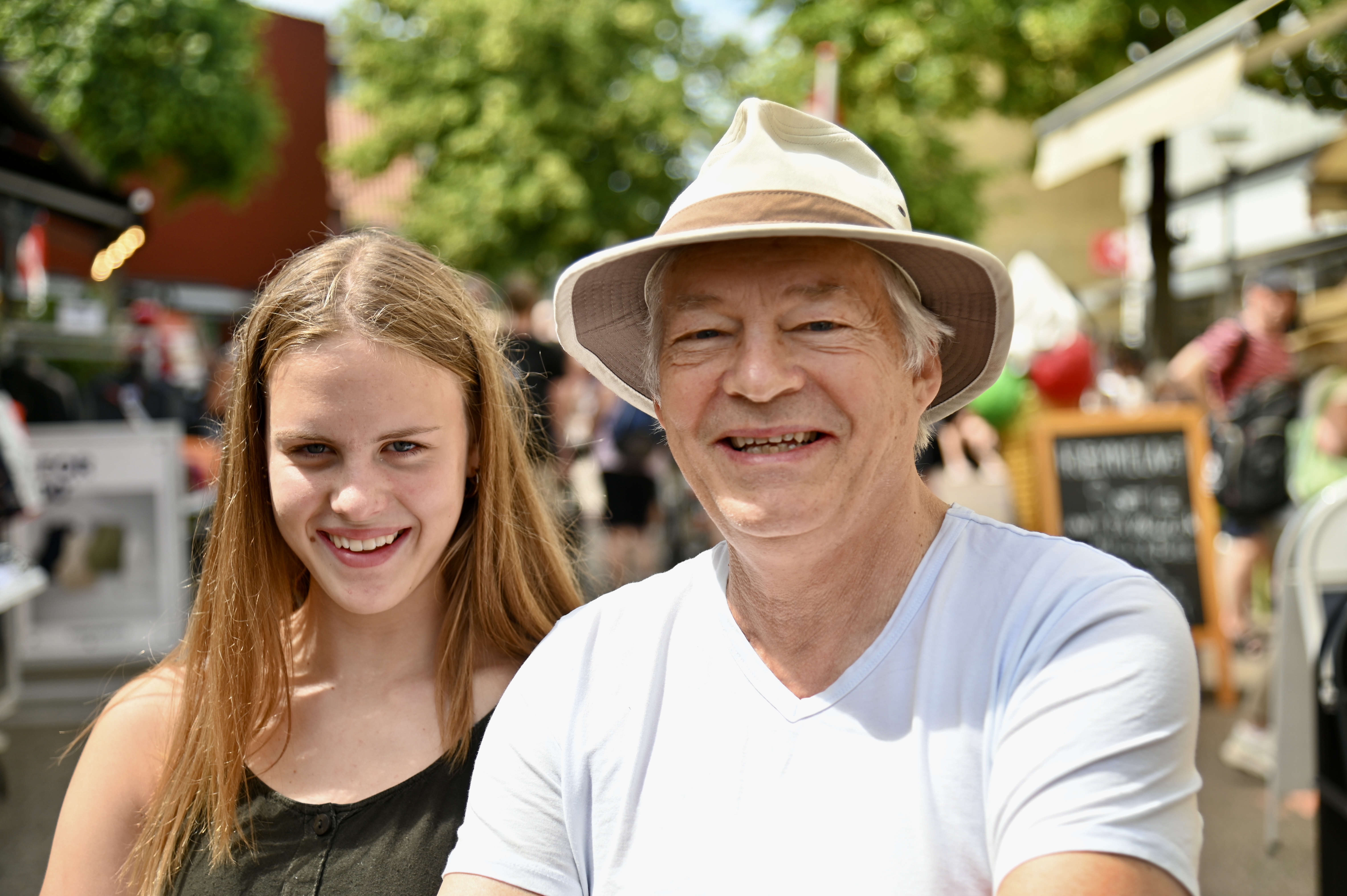 En pige og en ældre mand, der begge smiler