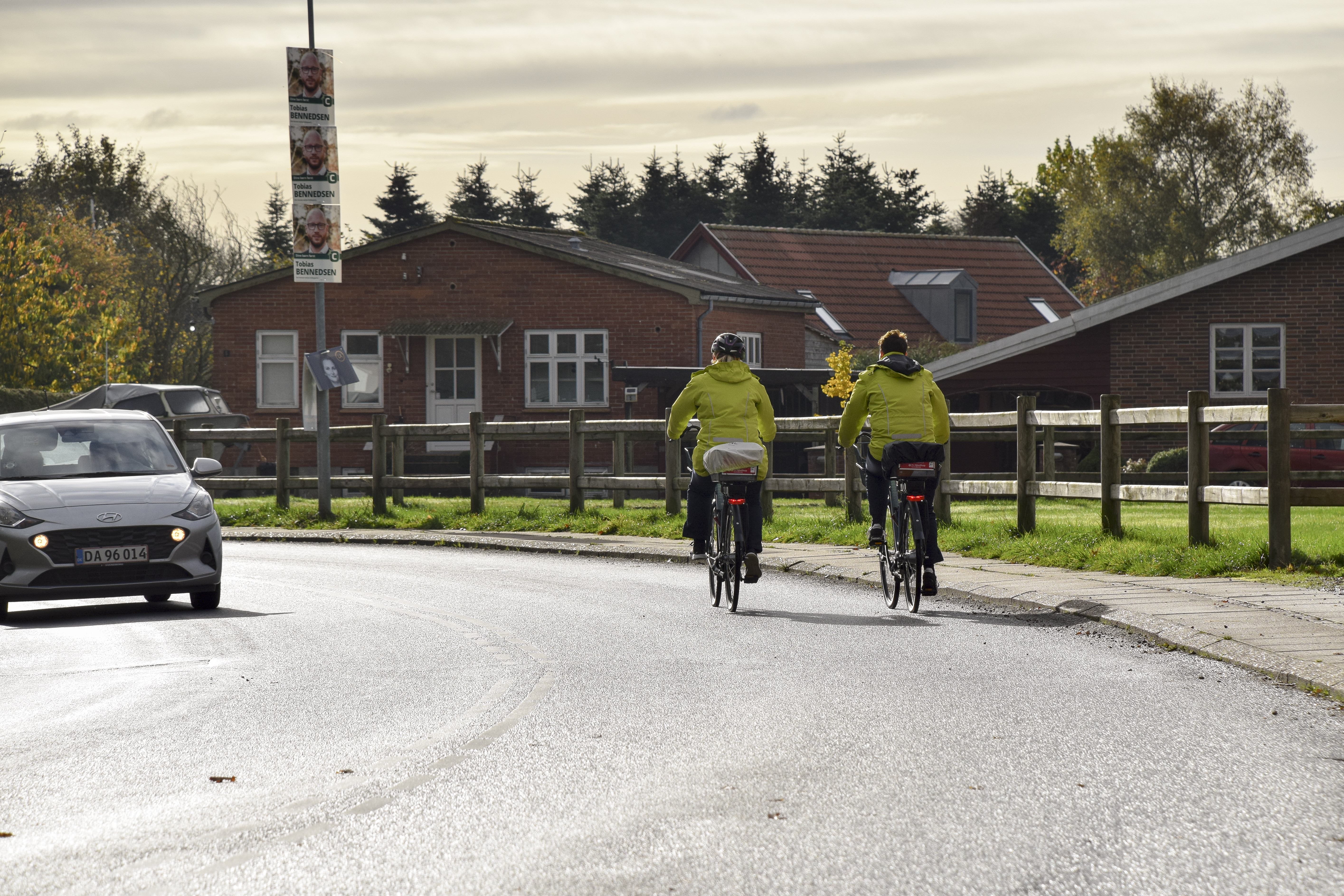 To cykelister med ens jakker på en vej