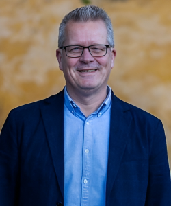 Mand i jakkesæt der smiler